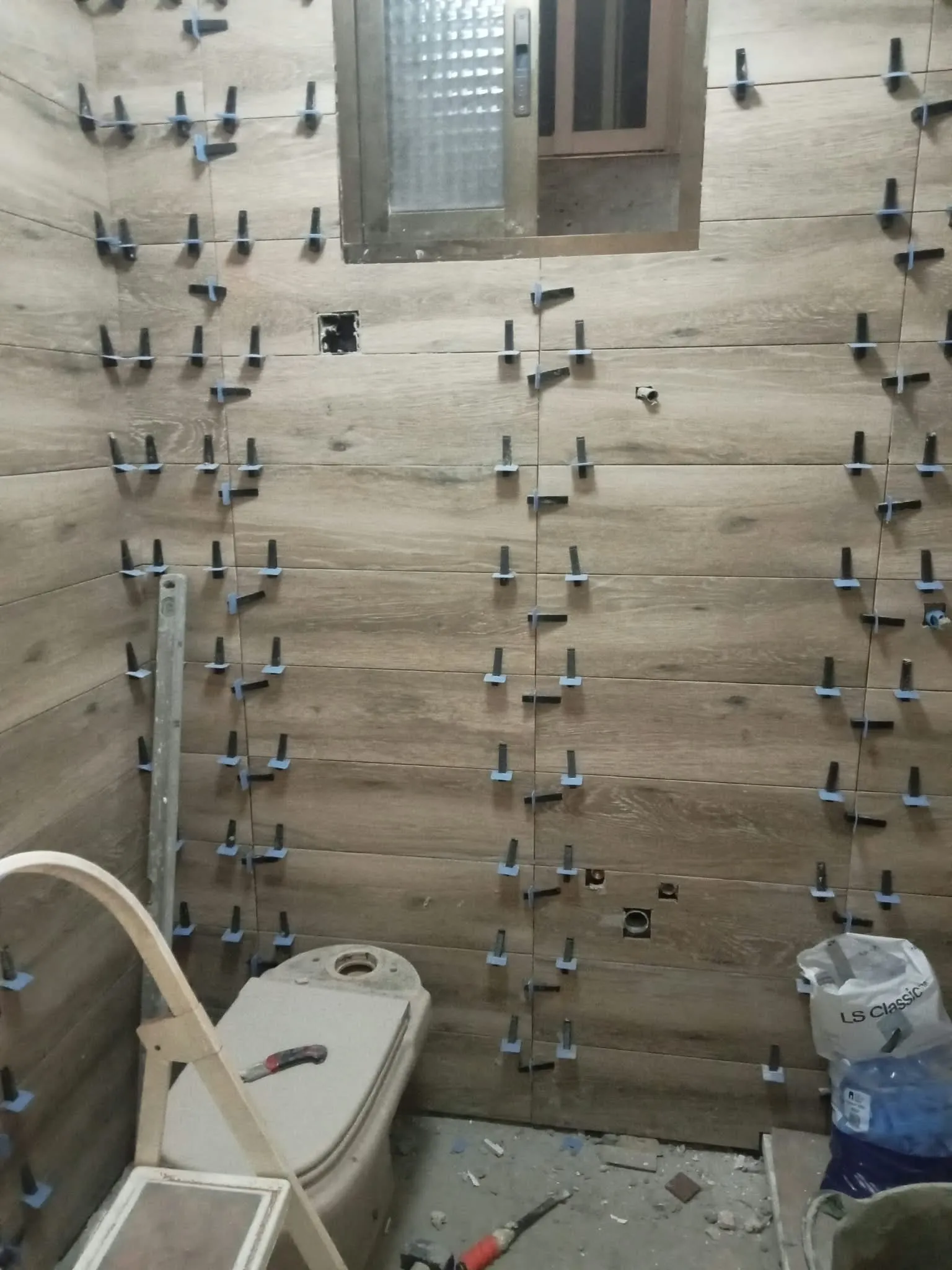 Baño en plena reforma alicatado con porcelánico imitación madera