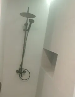 Ducha de obra con grifería negra hecha por Brandum